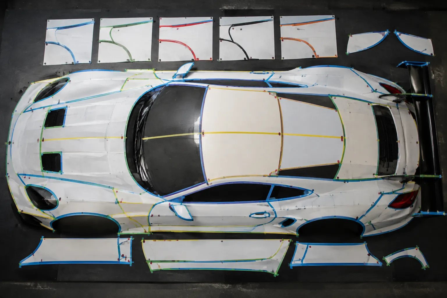 Vehicle-specific race car template mapped with panel seams vents wheel arches and candidate zones